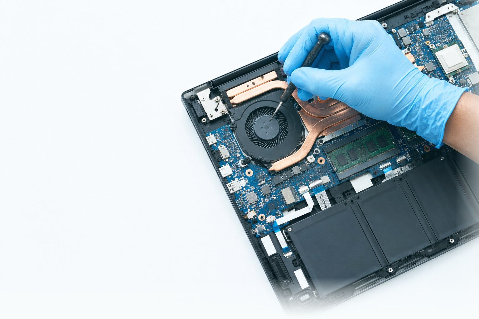 GRV technician in blue gloves probing a laptop motherboard beside the cooling fan during diagnosis